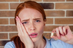 Girl holding cheek and wisdom tooth